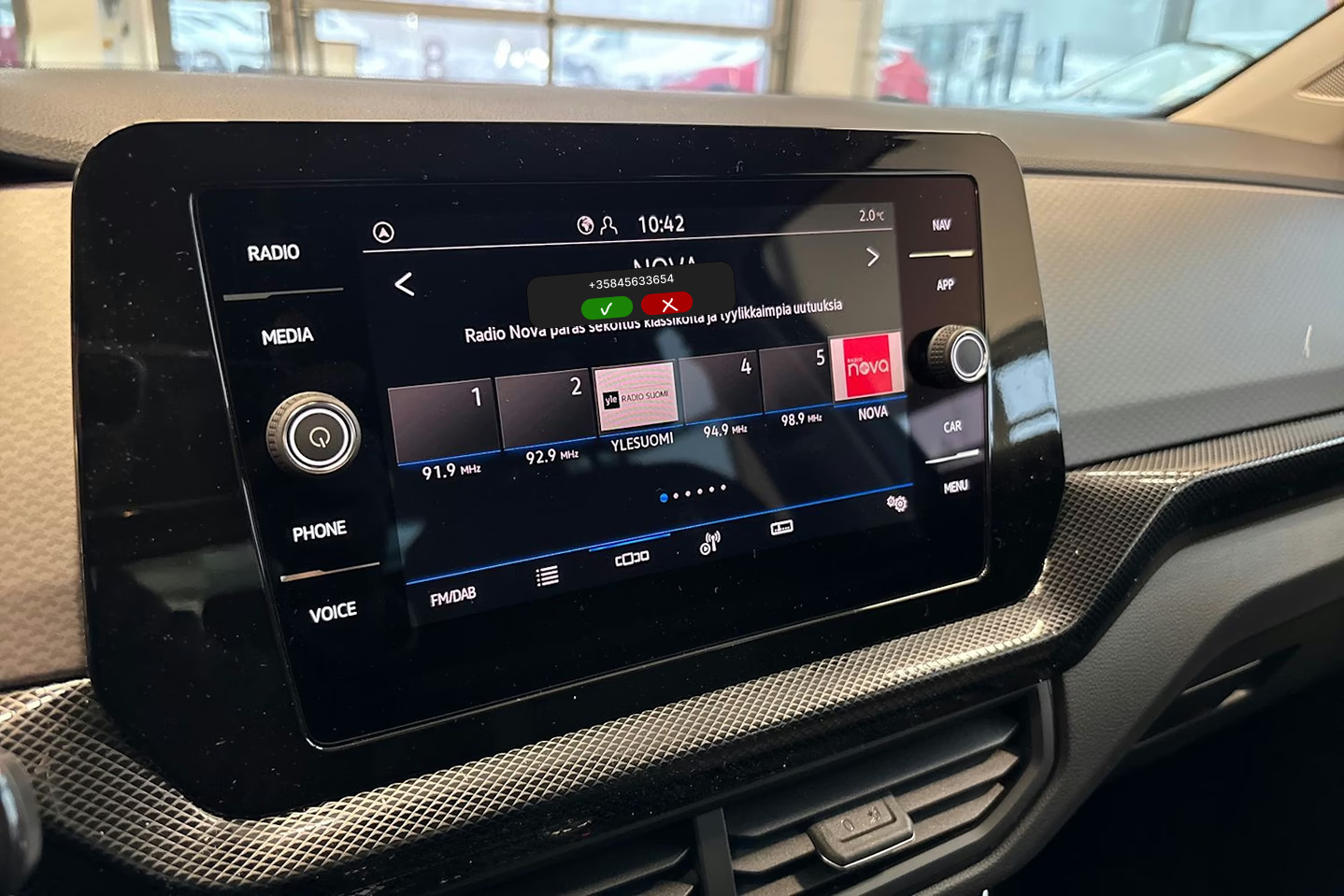 Volkswagen T-Cross infotainment screen with a small incoming call prompt over the radio interface.